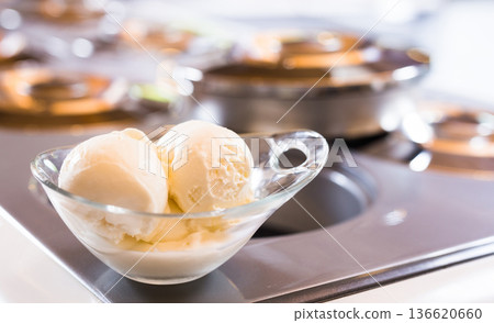 glass dessert bowl with vanilla ice cream on the table in the display case for distribution glass dessert bowl with vanilla ice cream on the table in the display case for distribution 136620660
