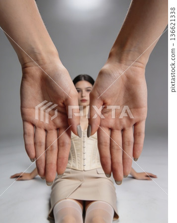 Artistic studio photograph capturing calm woman with precise hand framing and couture details 136621338