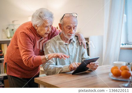 Senior coule working with tablet, having problem with technology. Senior coule working with tablet, having problem with technology. 136622011