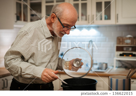 Older man cooking lunch in kitchen. Older man cooking lunch in kitchen. 136622015