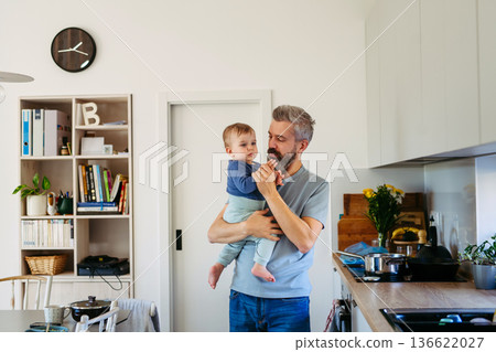Dad holding his little toddler son in arms. Dad holding his little toddler son in arms. 136622027