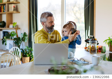 Dad working from homeoffice and taking care of toddler. 136622066