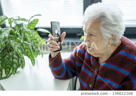Senior facing phone scams and digital safety. 136622108