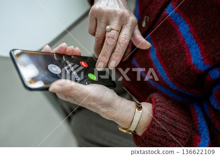 Senior facing phone scams and digital safety. 136622109