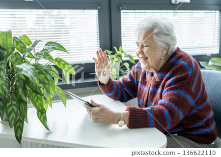 Senior woman having a video call on tablet. Senior woman having a video call on tablet. 136622110