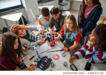 Teen students working as a team on robotics project in classroom. Teen students working as a team on robotics project in classroom. 136622136