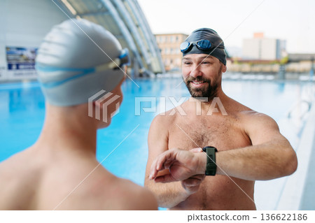 Father and teenage son enjoying swim training together. 136622186