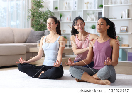 Three diverse women learning yoga at home Three diverse women learning yoga at home 136622987