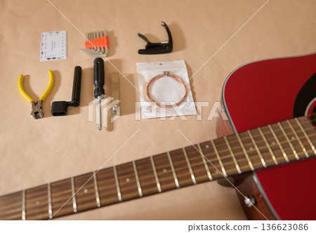 Guitar Maintenance and String Changing Tools Laid Out With Red Acoustic Guitar Guitar Maintenance and String Changing Tools Laid Out With Red Acoustic Guitar 136623086