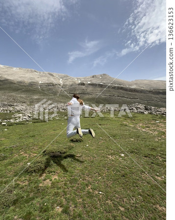 A man makes a jump against a mountain landscape. High quality photo 136623153