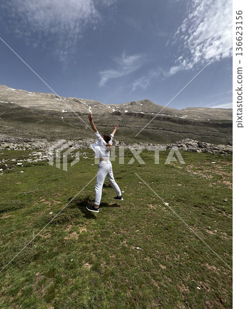 A man makes a jump against a mountain landscape. High quality photo A man makes a jump against a mountain landscape. High quality photo 136623156
