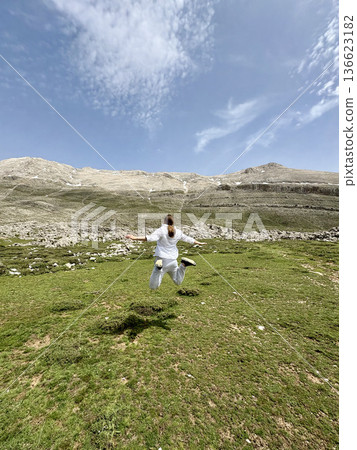 A man makes a jump against a mountain landscape. High quality photo A man makes a jump against a mountain landscape. High quality photo 136623182