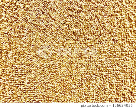 shimmering golden granular surface closeup radiating opulence and warmth ideal for luxury wallpaper or elegant commercial backdrop 136624035