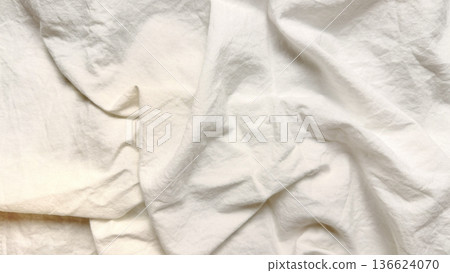 elegant crumpled white linen fabric texture unfolds in soft waves for minimalist wallpaper or subtle banner overlay 136624070