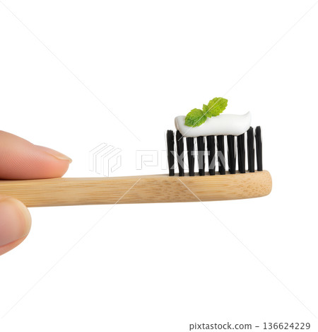 Eco-conscious concept, hand presenting a natural bamboo toothbrush with fresh mint toothpaste, isolated for dental hygiene and green lifestyle themes Eco-conscious concept, hand presenting a natural bamboo toothbrush with fresh mint toothpaste, isolated for dental hygiene and green lifestyle themes 136624229