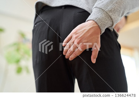 Asian man with a sore buttocks touching his hand 136624478