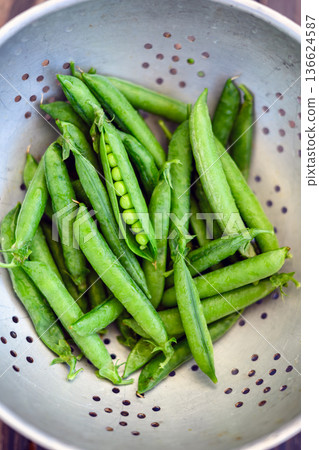 Fresh green peas in metal colander ready for washing Fresh green peas in metal colander ready for washing 136624587