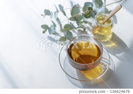 A minimalist tea time with beautiful sunshine and shade, featuring Earl Grey tea, honey, and eucalyptus. 136624676