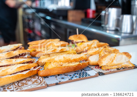 Spanish sandwiches bocadillos displayed on a tapas bar counter Spanish sandwiches bocadillos displayed on a tapas bar counter 136624721