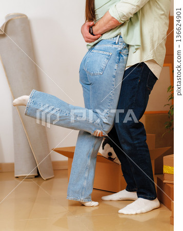 Couple is sharing a funny moment while organizing moving boxes in a home setting Couple is sharing a funny moment while organizing moving boxes in a home setting 136624901