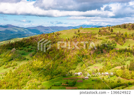 beautiful rural area in mountain landscape. european village on a steep green hill. amazing carpathians during spring. alpine countryside scenery in dappled light. simple living in remote highland 136624922