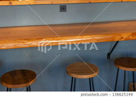A view of the cafe interior with counter seats and wooden stools 136625149
