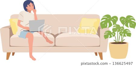home office lifestyle female freelancer working online on couch with indoor plant home office lifestyle female freelancer working online on couch with indoor plant 136625497