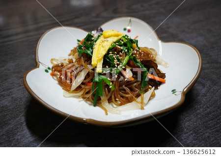 Traditional Korean Japchae, Stir-fried Glass Noodles with Mixed Vegetables, Spinach, Carrots, and Egg Garnish 136625612