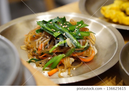 Traditional Korean Japchae, Stir-fried Glass Noodles with Mixed Vegetables, Spinach, Carrots, and Egg Garnish 136625615