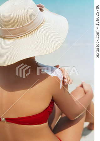 Young woman with healthy skin applying suncream,sun protection on tanned back Young woman with healthy skin applying suncream,sun protection on tanned back 136625786