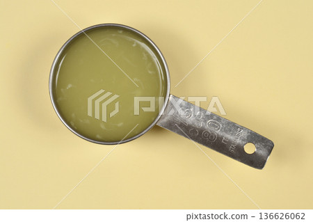 Fresh lemon juice in a measuring cup Fresh lemon juice in a measuring cup 136626062