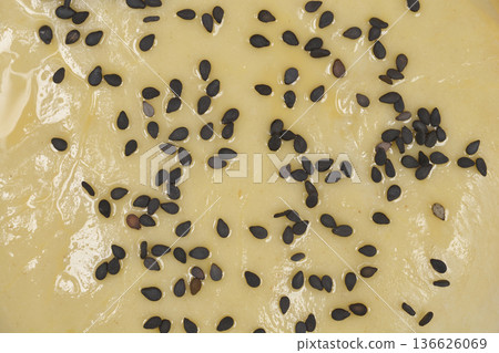 Extreme macro of black sesame seeds on raw dough Extreme macro of black sesame seeds on raw dough 136626069