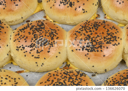 Close-up of baked burger buns with black sesame seeds Close-up of baked burger buns with black sesame seeds 136626070