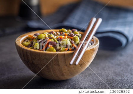 Fresh salad with edamame beans in bowl on black table. 136626892