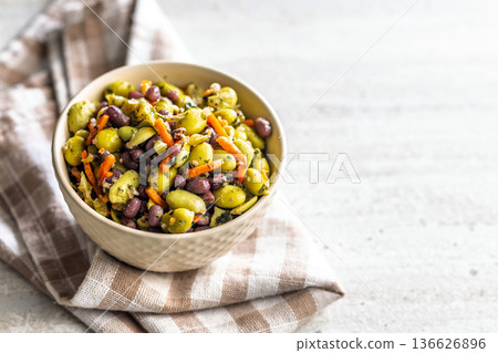 Fresh salad with edamame beans in bowl on checkered napkin. Fresh salad with edamame beans in bowl on checkered napkin. 136626896