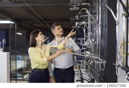 Couple choosing taps and shower for bathroom standing at the building market. 136627306