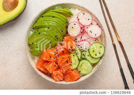 Salmon poke bowl with avocado, radish, cucumber and rice on light beige background top view 136628646