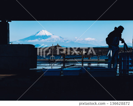 Mount Fuji in winter as seen between the silhouette of Ogawa Fishing Port in Yaizu City, Shizuoka Prefecture, and the buildings 136628872