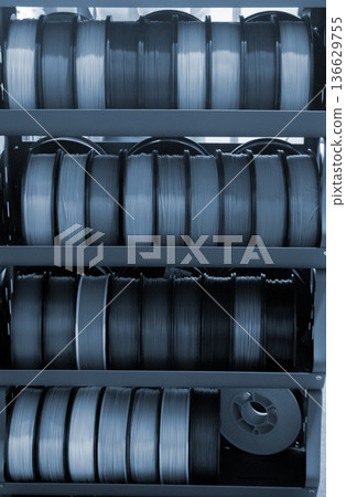 Spool of plastic wire for 3D printing. Different spool with plastic close-up. Component for 3d printing. Printing accessories. Concept 3D printing technology. Additive progressive FDM technologies Spool of plastic wire for 3D printing. Different spool with plastic close-up. Component for 3d printing. Printing accessories. Concept 3D printing technology. Additive progressive FDM technologies 136629755