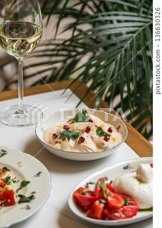 Restaurant appetizers with hummus tomato and wine 136630326