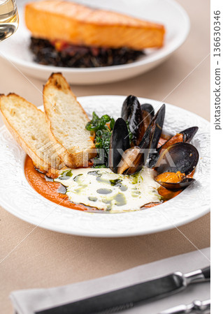 Mussels soup and salmon with wild rice Mussels soup and salmon with wild rice 136630346