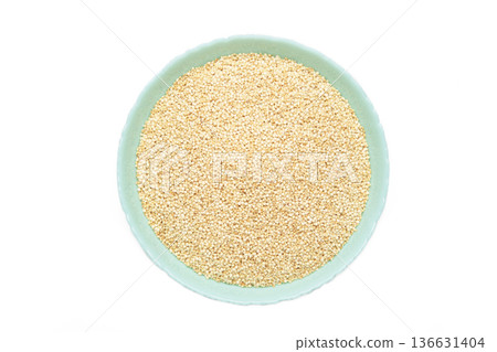 Organic white quinoa seeds in blue plate isolated on white background. Organic white quinoa seeds in blue plate isolated on white background. 136631404