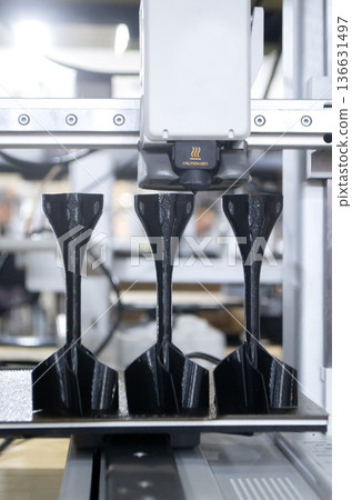 3D printer. 3D printer printing object close-up. 3D printer printing model black color. Working 3D printer. Concept printing technology. New modern additive progressive technology. FDM technologies 3D printer. 3D printer printing object close-up. 3D printer printing model black color. Working 3D printer. Concept printing technology. New modern additive progressive technology. FDM technologies 136631497