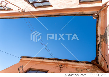 Low-angle upward view of sky framed by old European building Low-angle upward view of sky framed by old European building 136631796