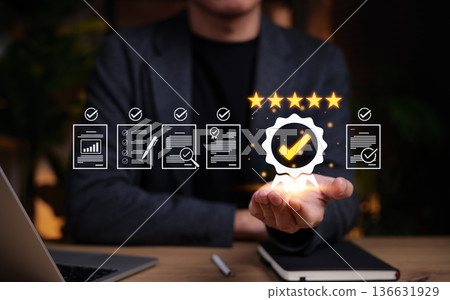 Quality assurance and compliance concept. Businessman holding a glowing badge with check mark and five stars. Surrounding document icons represent evaluation, audit, certification and process control. 136631929