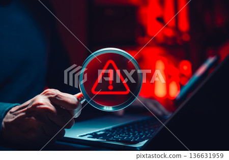 Cyber threat detection and data risk warning concept. Person holding magnifying glass with digital alert symbol representing cybersecurity breach, malware investigation, system vulnerability analysis, 136631959