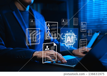 Businessman using AI-powered software on laptop for automated resume screening and candidate selection. Concept of artificial intelligence in HR tech, AI recruitment analytics and digital hiring. 136631975