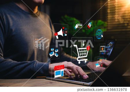E-commerce and online shopping concept. Person using laptop with digital icons of cart, payment, review, delivery, and marketing, representing digital retail, consumer behavior and sales strategy. E-commerce and online shopping concept. Person using laptop with digital icons of cart, payment, review, delivery, and marketing, representing digital retail, consumer behavior and sales strategy. 136631978