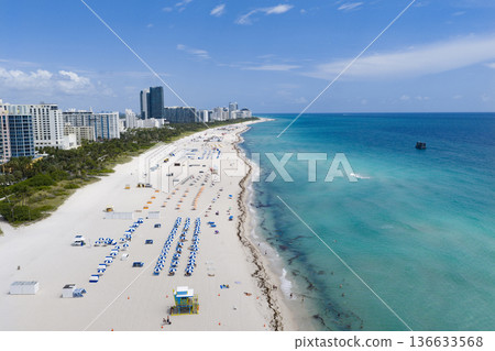 Drone aerial view of Miamis sandy beach. Miami coastline. Wide drone shot of Miami Beach and ocean waves. Miami beachscape captured from above. Oceanfront Miami resorts by drone. 136633568