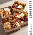 Exquisite boxes with meat snacks, cheese, nuts and fruits. Exquisite snack boxes are filled with delicacies. 136633628